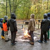 Wir backen Stockbrot über dem Lagerfeuer. Kinder mit Stockbrot