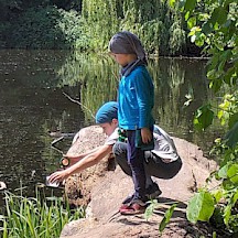 Kinder mit Becherlupe am Teich