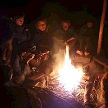 Wir sitzen in der Nacht ums Lagerfeuer. Kinder ums Lagerfeuer im Dunkeln