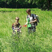 Kind und Erwachsener in einer Wiese