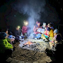 Kinder im Dunkeln ums Feuer