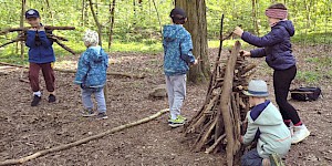 Kinder bauen Turm aus Stöcken