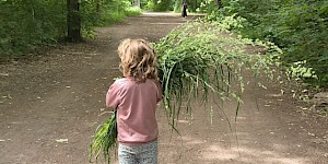 Kind mit Grasbündel